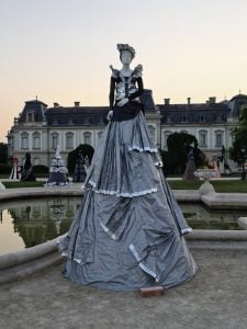 Tall statue of a woman dressed in plastic in front of Keszthely palace