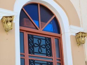 Gold light fixtures on church door in Livadi, Serifos, Greece
