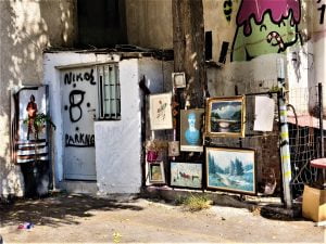 Framed art hanging on the fence of a carpark in Psyrri, Athens, Greece