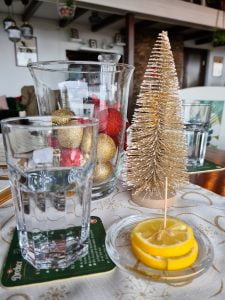 Glass of water with a plate of lemon wedges on a restaurant table
