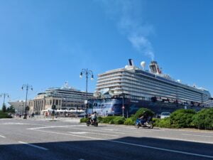 Two massive cruise ships docked side by side against a blue sky