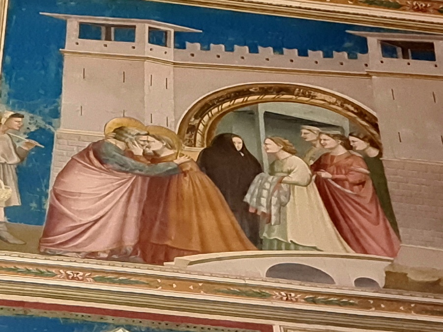 A fresco of a couple kissing at the gates of Jerusalem unwatched by the gorup of five women in the background. 