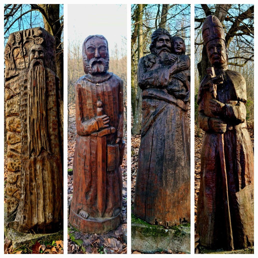 Four wooden carvings L2R - a bearded hearmit, St Paul wth sword and bible, St Joseph with the baby Jesus, and Pope John Paul with his hat and cross. 