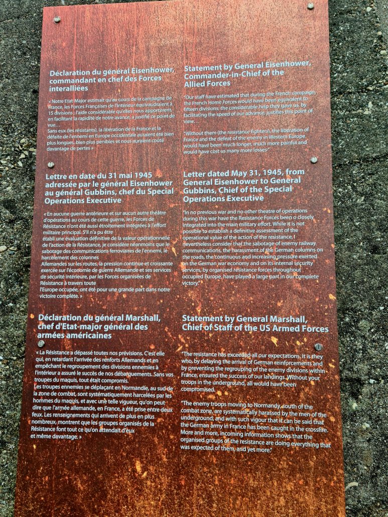 Bronze plaque with white lettering. Text on the left is in French. Text on the right is in English: Statement by General Eisenhower Commander-in-Chief of the Allied Forces Our staff have estimated that during the French campaign the French Home Forces would have been equivalent of fifteen divisions, the considerable help they gave us by facilitating the speed of our advance, justifies this point of view. Without them (the resistance figthers) the liberation of France and the defeat of the enemy in Western Europe would have been much longer, much more painful and would have cost us many more losses." Letter dated May 31, 1945, from General Eisenhower to General Gubbins, Chief of the Special Operations Executive "in no previous war and no other theater of operations during this war have the Resistance Forces been o [sic] closely integrated into the main military effort. While it is not possible to establish a definitive assessment of the operational value of the action of the resistance, 1 nevertheless consider that the sabotage of enemy railway communications, the harassment of the German columns on the roads, the continuous and increasing pressure exerted on the German war economy and on its internal security services, by organized resistance forces throughout occupied Europe, have played a large part in our complete Victory." Statement by General Marshall, Chief of Staff of the US Armed Forces "The resistance has exceeded all our expectations. It is they who, by delaying the arrival of German reinforcements and by preventing the regrouping of the enemy divisions within France, ensured the success of our raids. Without your troops in the underground, all would have been compromised. The enemy troops moving to Normandy south of the combat zone are systematically harassed by the men of the underground, and with such vigor that it can be said that the German army in France has been caught in the crossfire. More and more, incoming information shows that the organised groups of the resistance are doing everything that was expected of them, and yet more."