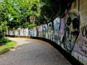Curved wall on featuring portraits of famous people , graffiti style.