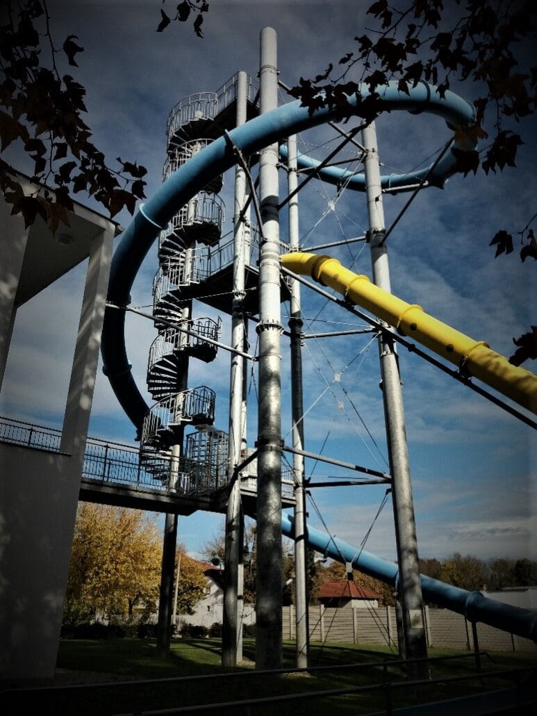 massive slide in blue and yellow with a curved metal stairs leading to the top