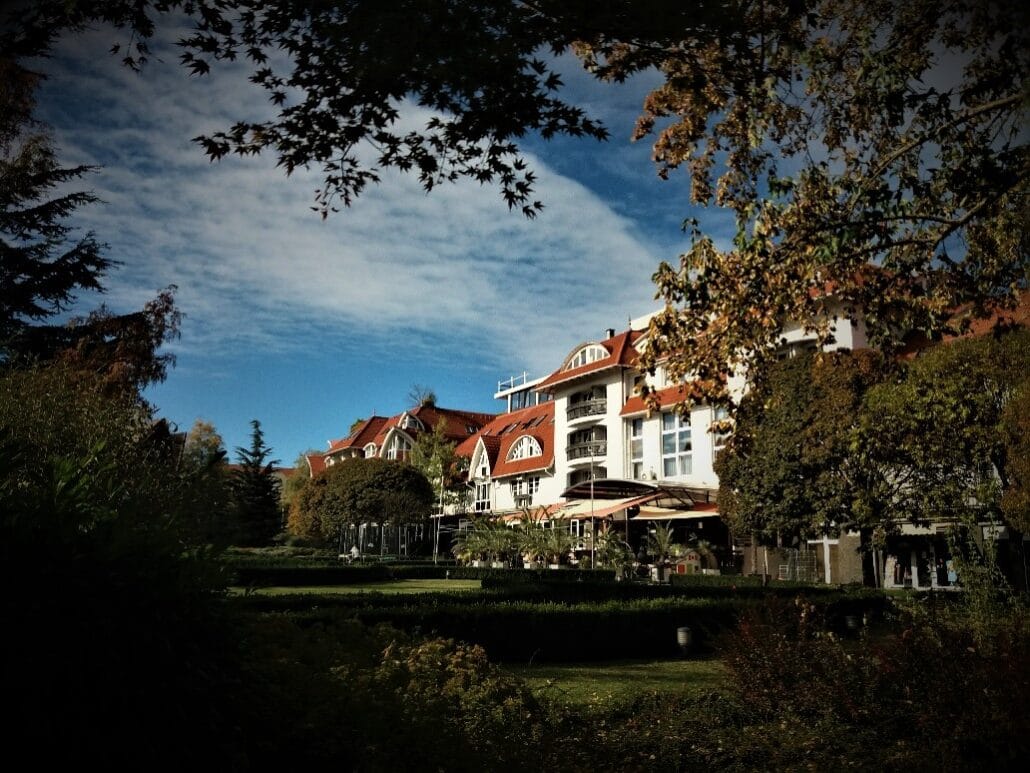 redroofed hotel with vaulted white windows set amid lawns and green trees