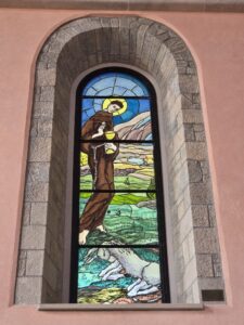 St Anthony of Padua and the Miracle of the Mule — a stained-glass window in the new Church of St Anthony at Humac, depicting the saint holding the Blessed Sacrament before a kneeling mule.