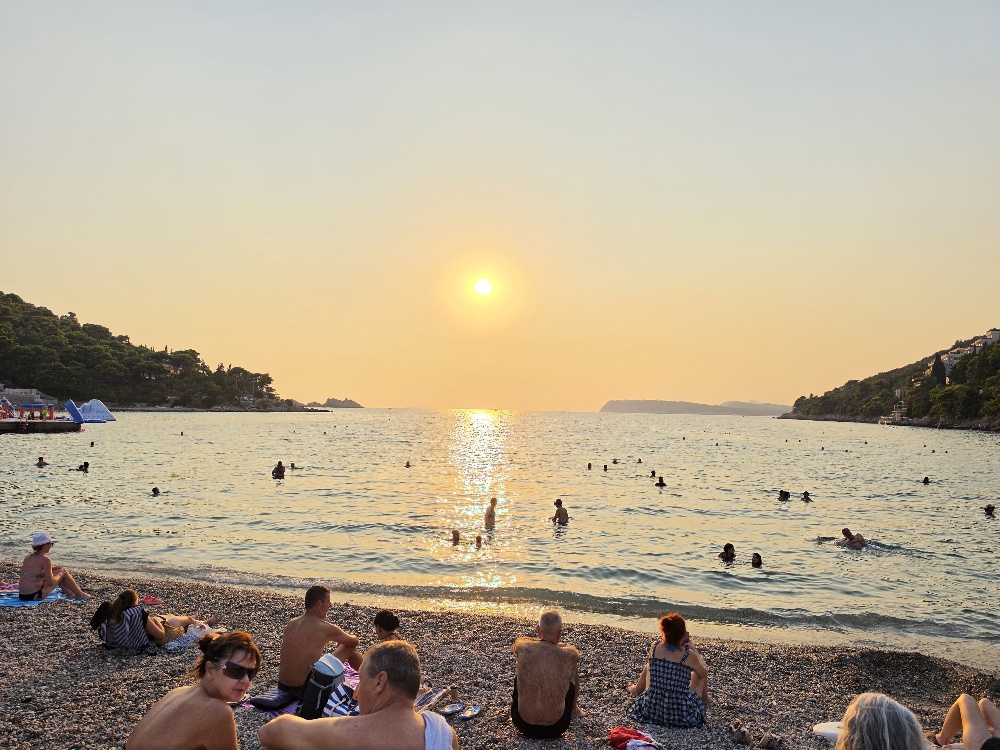 beginning of a sunset - pebble beach - people swimming and sunbathing